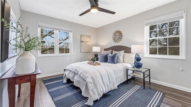 bedroom with a ceiling fan, baseboards, and wood finished floors