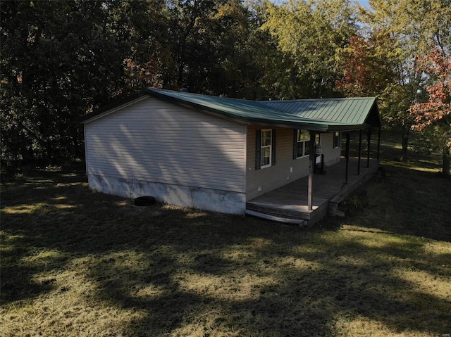 view of home's exterior with metal roof and a yard