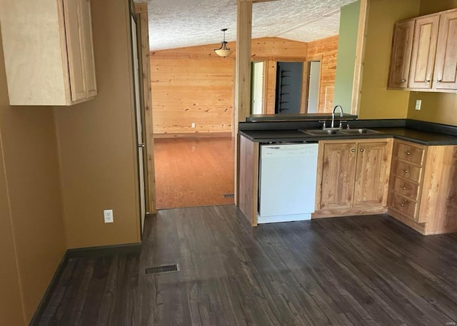 kitchen featuring lofted ceiling, white dishwasher, a sink, visible vents, and dark countertops