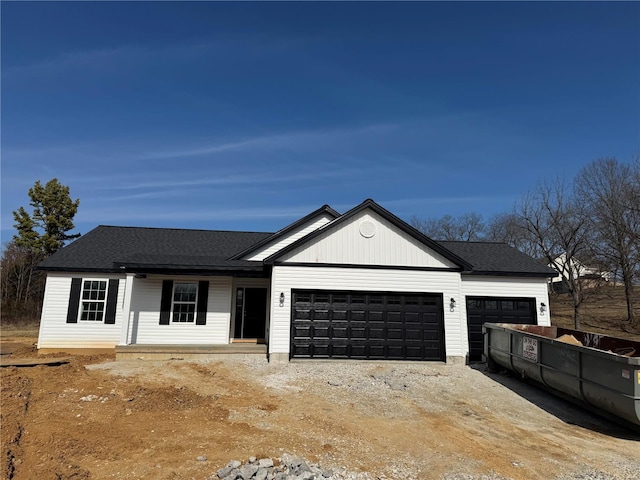 modern inspired farmhouse with dirt driveway, a shingled roof, covered porch, and a garage