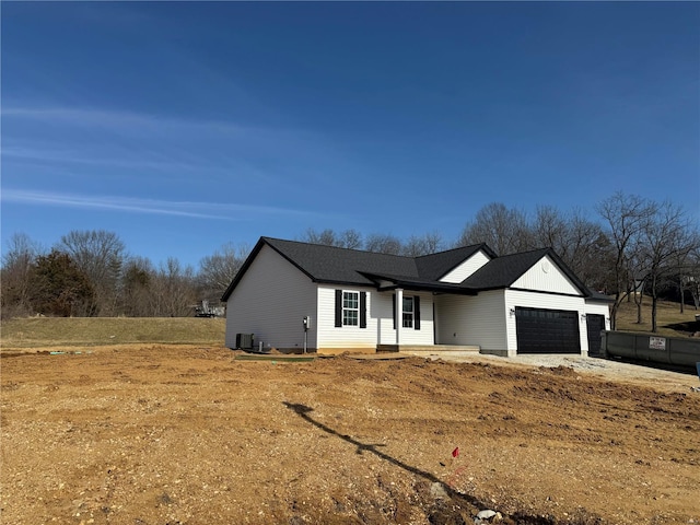 ranch-style house featuring an attached garage and central AC