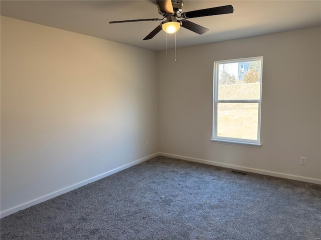 spare room featuring carpet floors, baseboards, visible vents, and ceiling fan