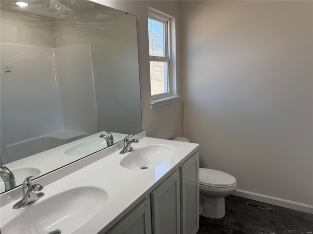 full bath featuring double vanity, a sink, and baseboards