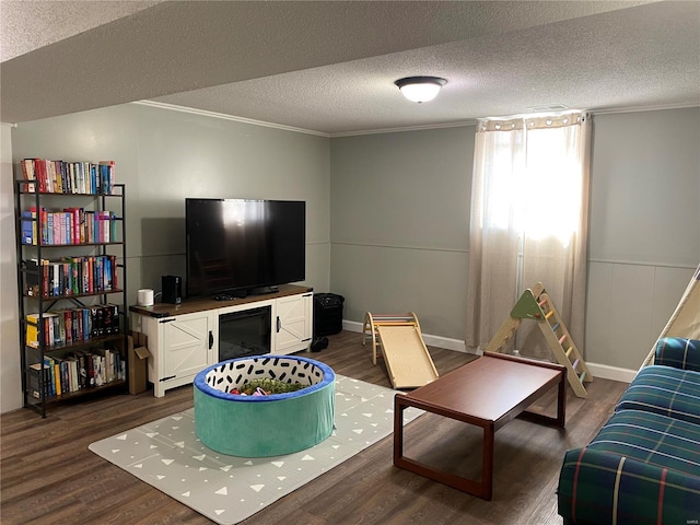 living room with dark wood finished floors, a textured ceiling, and crown molding