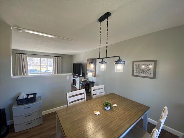 dining area featuring dark wood finished floors and baseboards