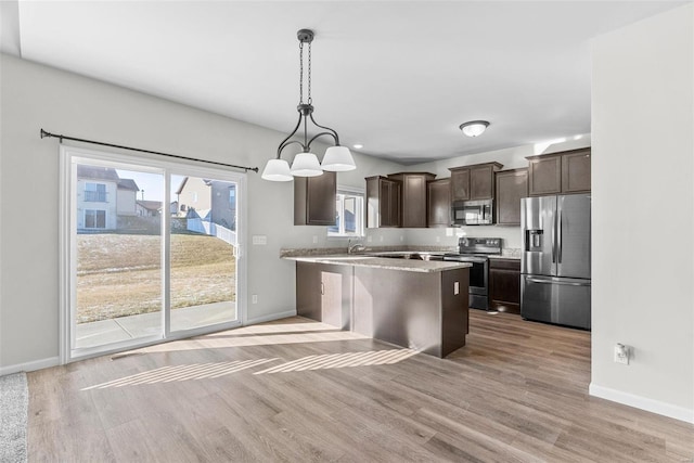 kitchen featuring appliances with stainless steel finishes, baseboards, light wood-style floors, and dark brown cabinets