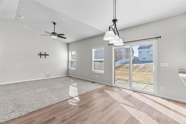 interior space with lofted ceiling, wood finished floors, a ceiling fan, and baseboards