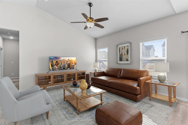 living room with ceiling fan, lofted ceiling, plenty of natural light, and wood finished floors