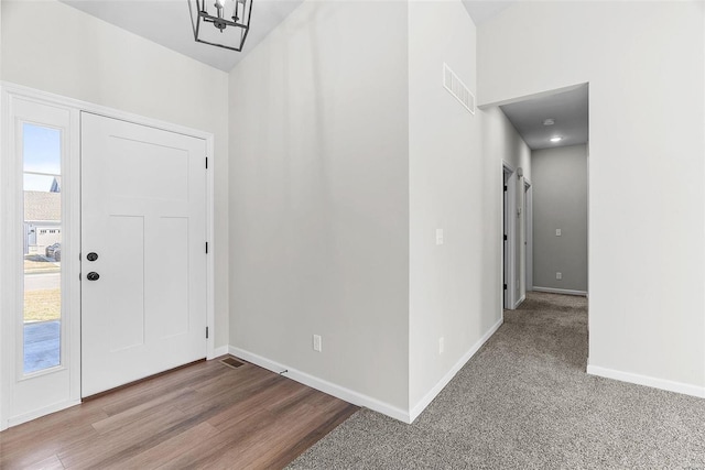 entryway with visible vents, plenty of natural light, baseboards, and wood finished floors