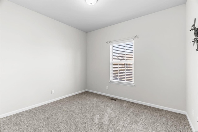 spare room featuring carpet, visible vents, and baseboards