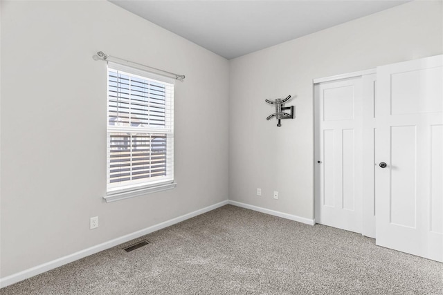 unfurnished bedroom featuring carpet floors, a closet, visible vents, and baseboards