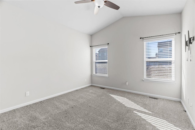 spare room featuring lofted ceiling, baseboards, visible vents, and a healthy amount of sunlight