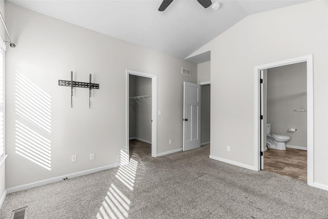 unfurnished bedroom featuring lofted ceiling, visible vents, a spacious closet, and carpet flooring