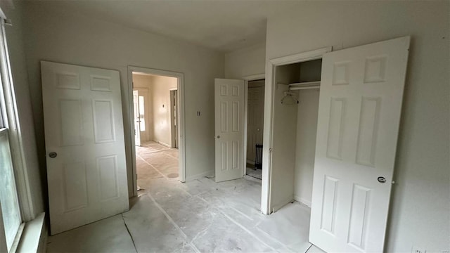 unfurnished bedroom with a closet and baseboards