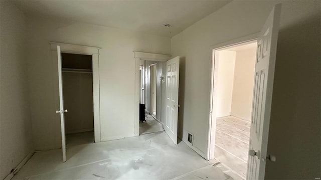 unfurnished bedroom with concrete flooring, a closet, and visible vents