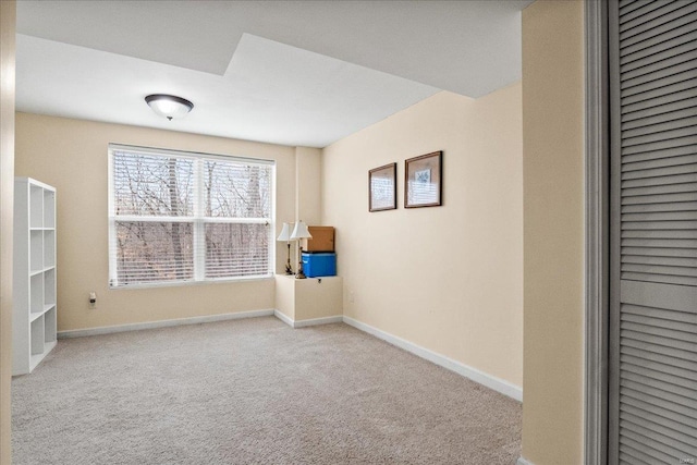 carpeted empty room featuring baseboards