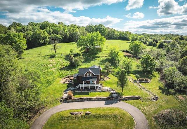 drone / aerial view featuring a wooded view