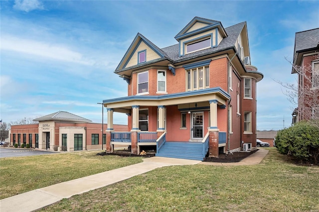 view of front of house with a front yard, covered porch, brick siding, and cooling unit