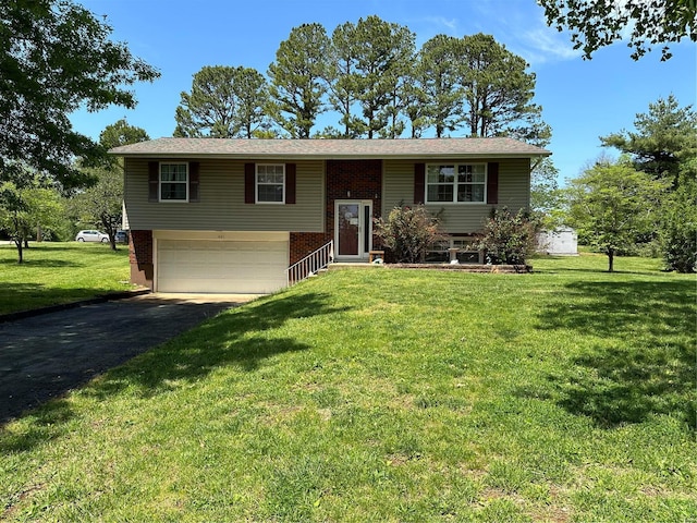 split foyer home featuring a front lawn, brick siding, driveway, and an attached garage