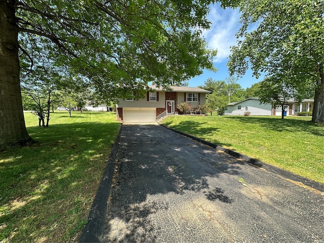 bi-level home featuring driveway, brick siding, a front lawn, and an attached garage