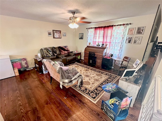 living area featuring a textured ceiling, ceiling fan, and wood finished floors