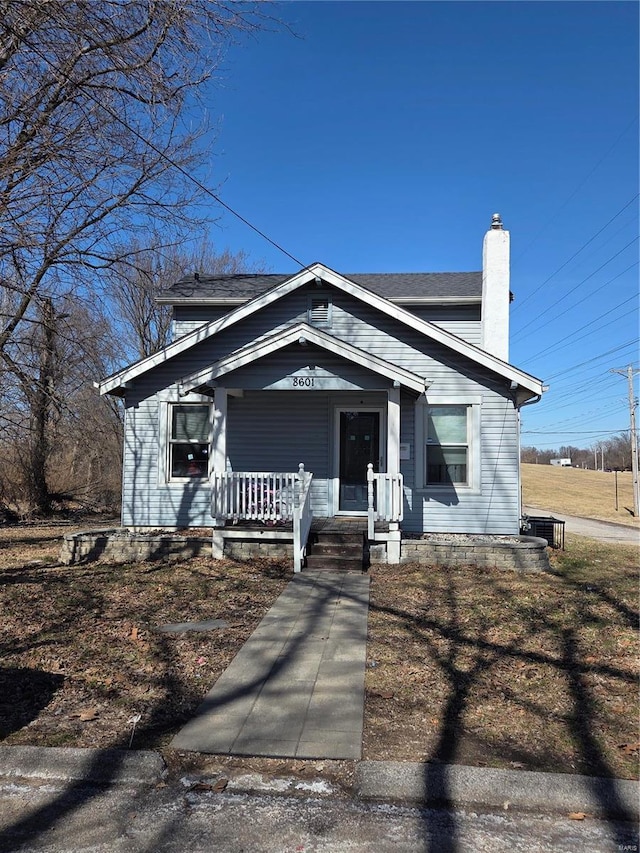 view of front of property with covered porch, central AC, and a chimney