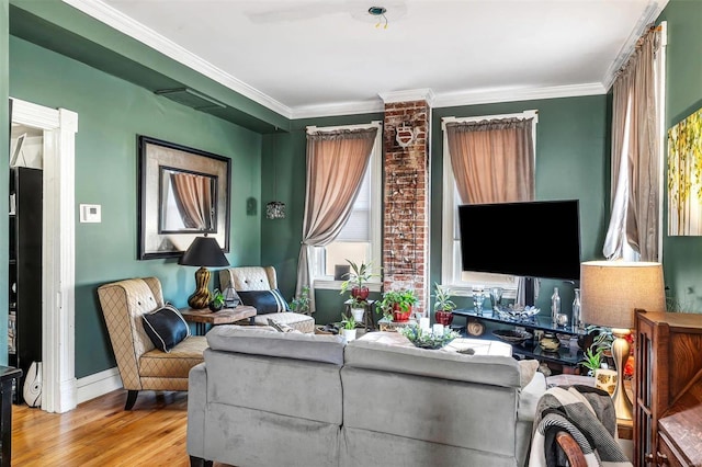 living room featuring crown molding, baseboards, and wood finished floors