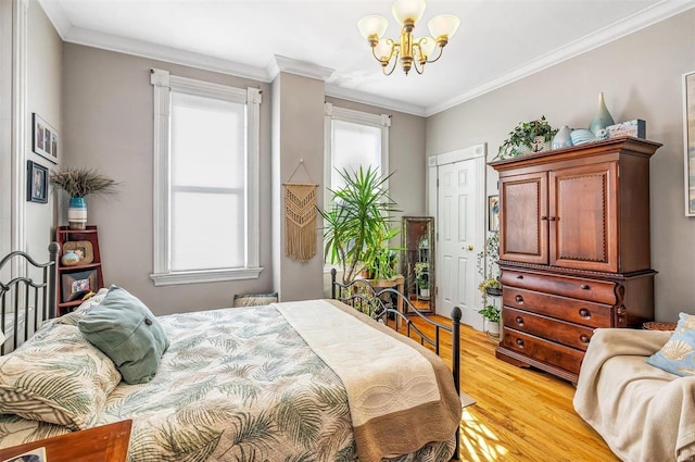 bedroom featuring ornamental molding, light wood finished floors, and a chandelier