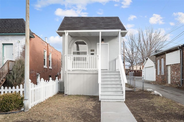 shotgun-style home featuring fence, a porch, stairs, and a shingled roof