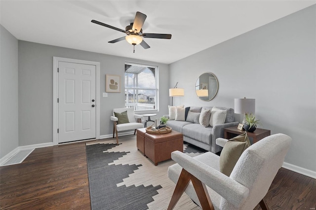 living room with a ceiling fan, baseboards, and wood finished floors