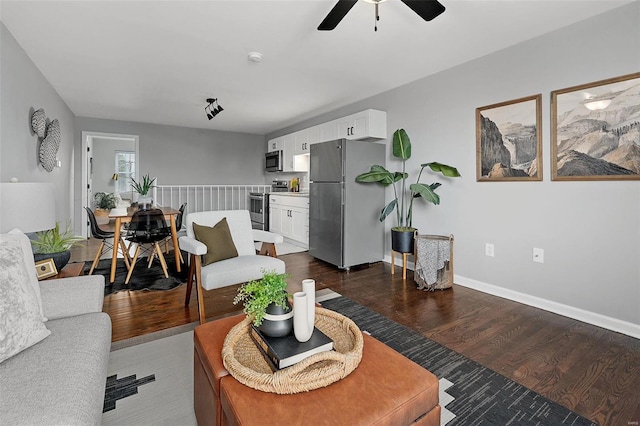 living area featuring a ceiling fan, baseboards, and dark wood-style flooring