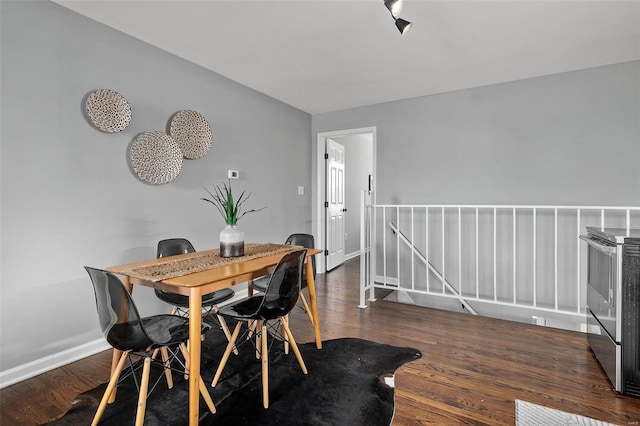 dining area with baseboards and wood finished floors