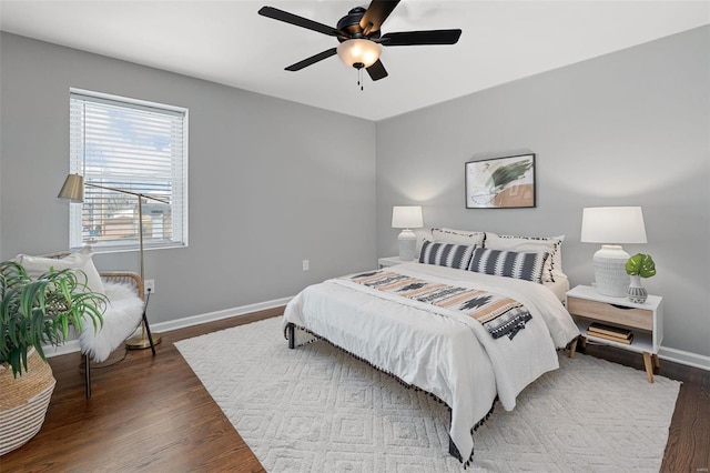 bedroom with ceiling fan, baseboards, and wood finished floors