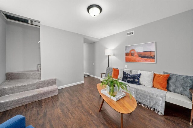 living room with stairs, wood finished floors, visible vents, and baseboards