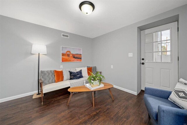 living area with visible vents, baseboards, and wood finished floors