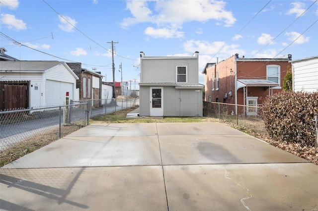 back of property with a garage, an outdoor structure, and fence