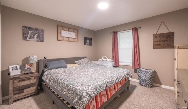 bedroom featuring light carpet and baseboards