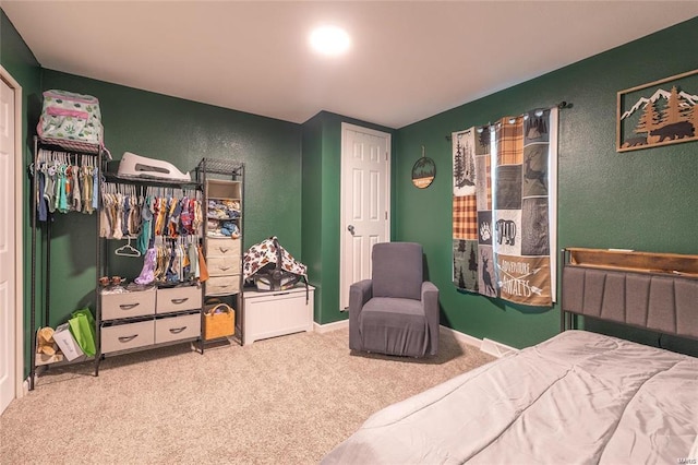 bedroom featuring carpet and a textured wall