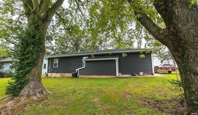 back of property with cooling unit and a lawn