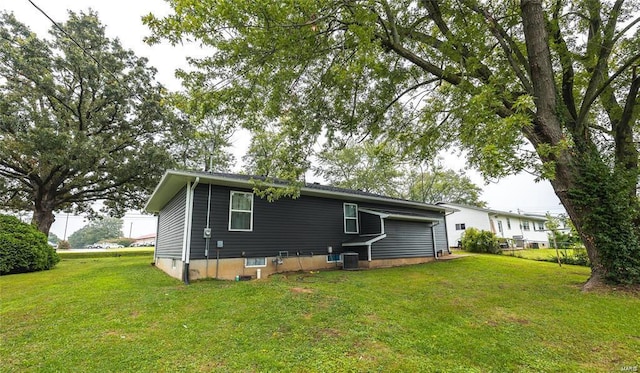 rear view of property with cooling unit and a lawn