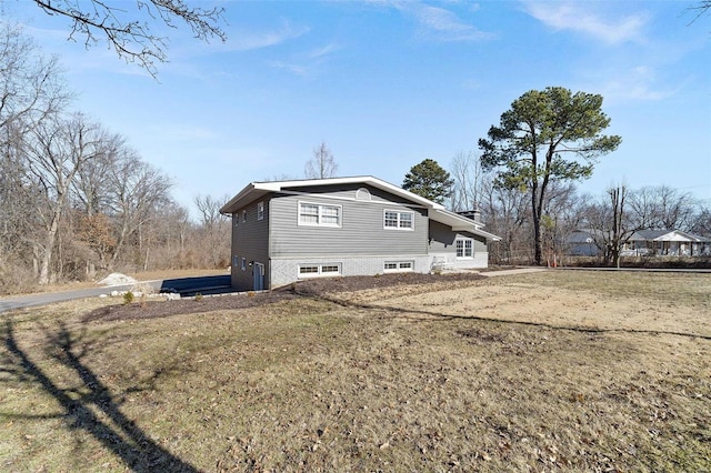 view of side of home with a yard