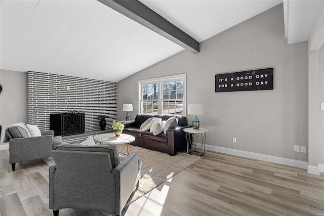 living area with lofted ceiling with beams, a tiled fireplace, wood finished floors, and baseboards