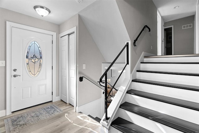 entrance foyer featuring stairs, wood finished floors, visible vents, and baseboards