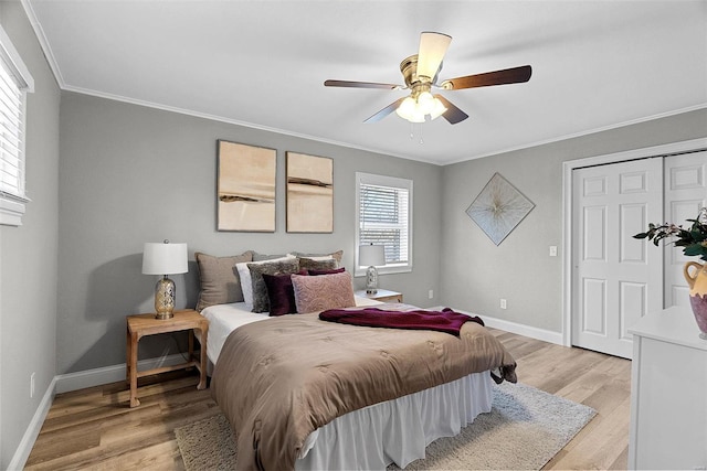 bedroom with ornamental molding, light wood-type flooring, ceiling fan, and baseboards