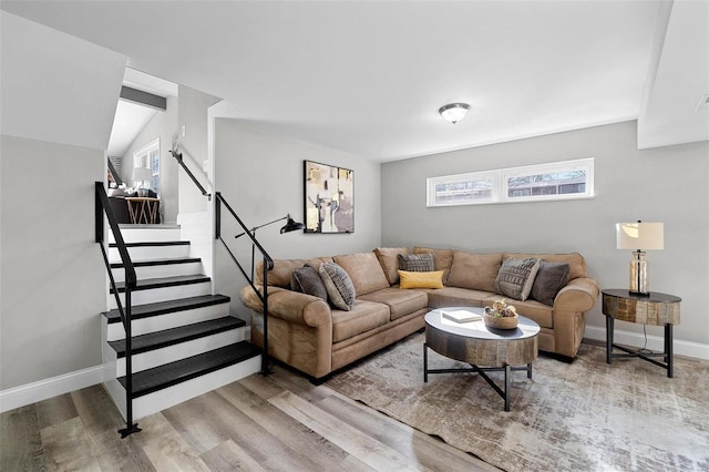 living room featuring baseboards, stairway, and wood finished floors