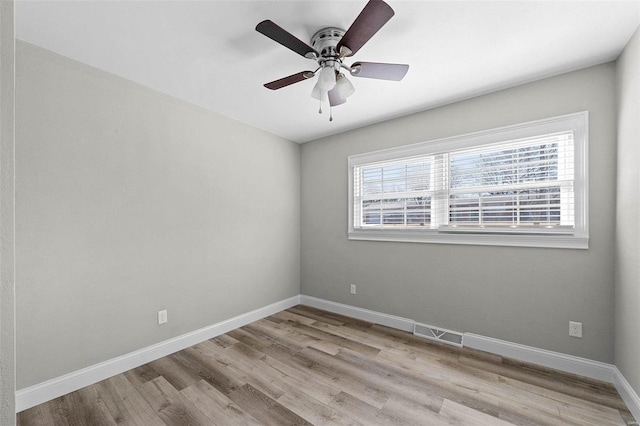 unfurnished room featuring a ceiling fan, visible vents, baseboards, and wood finished floors