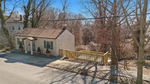 view of front of property with roof with shingles and a chimney