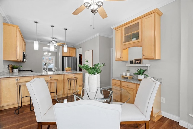 dining area featuring baseboards, dark wood-style flooring, a ceiling fan, and crown molding