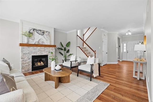 living room with baseboards, stairs, ornamental molding, and wood finished floors