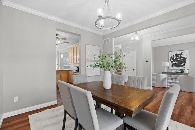 dining space with ornamental molding, wood finished floors, visible vents, and baseboards